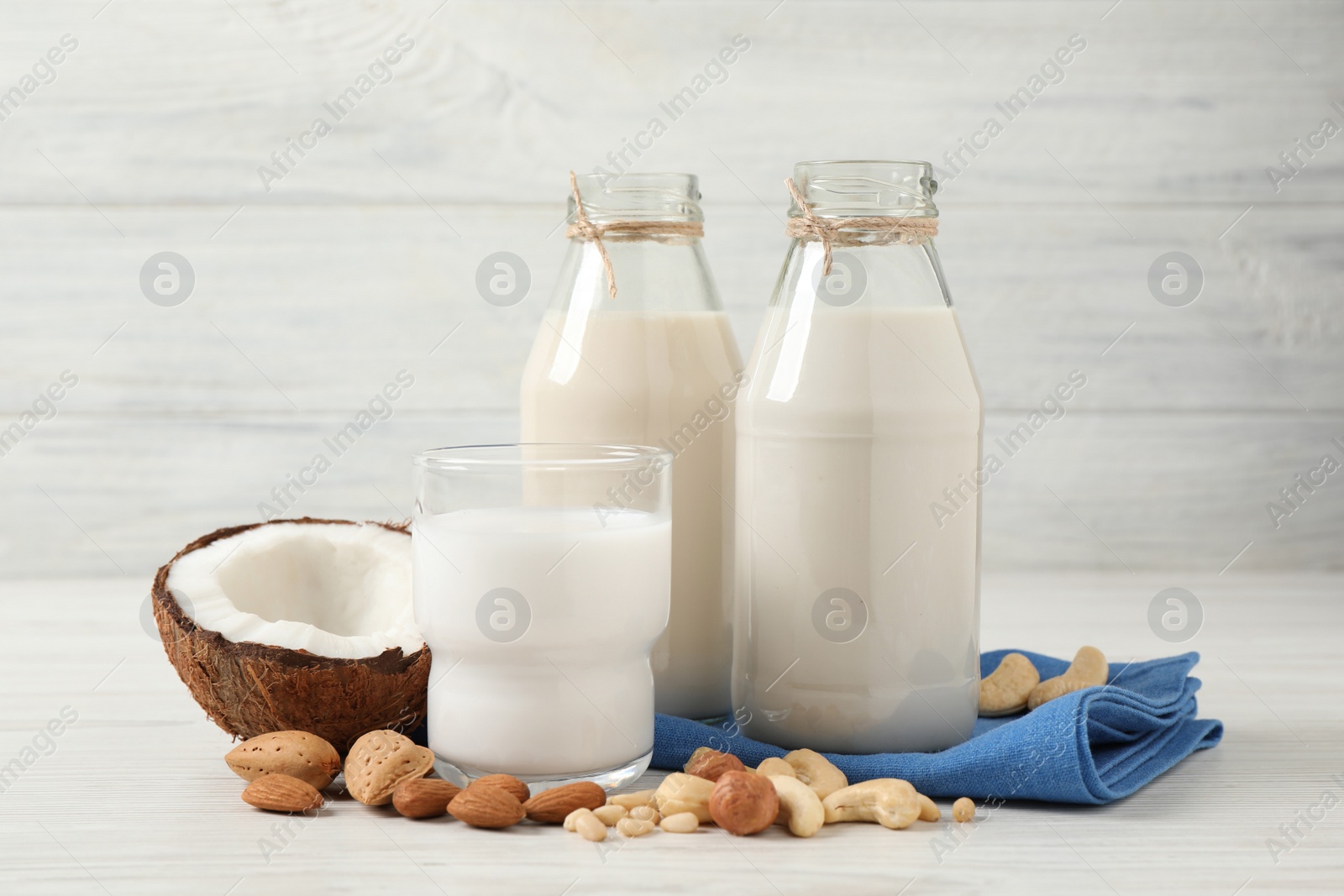 Photo of Different nut milks on white wooden table