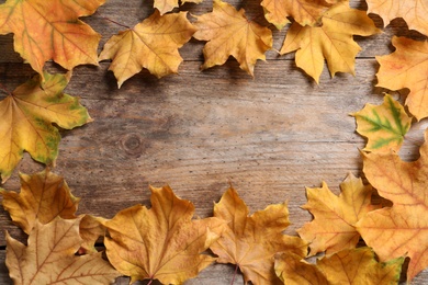 Photo of Composition with autumn leaves and space for text on wooden background, top view