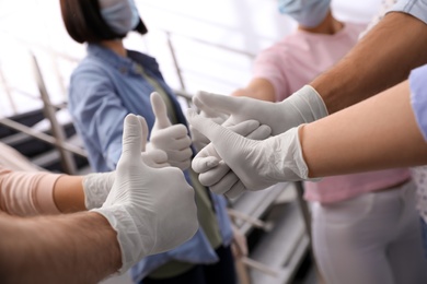 Group of people in white medical gloves showing thumbs up on blurred background, closeup