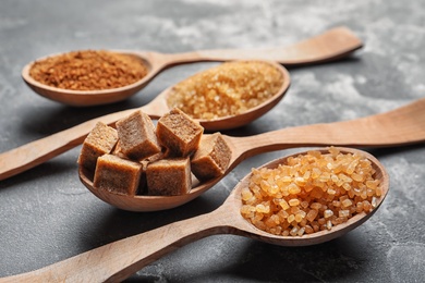 Spoons with brown sugar on table