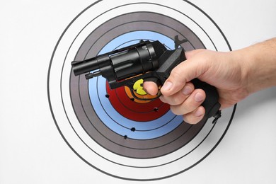 Photo of Man with handgun near shooting target, closeup