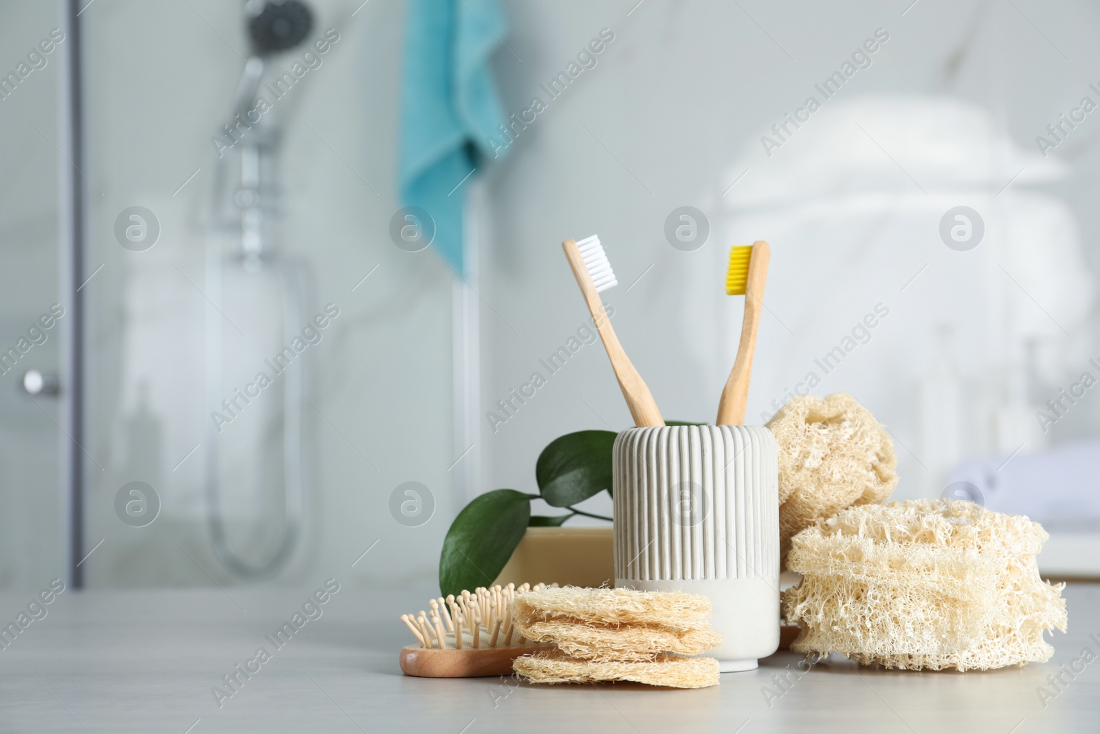 Photo of Composition with natural loofah sponges on table in bathroom. Space for text