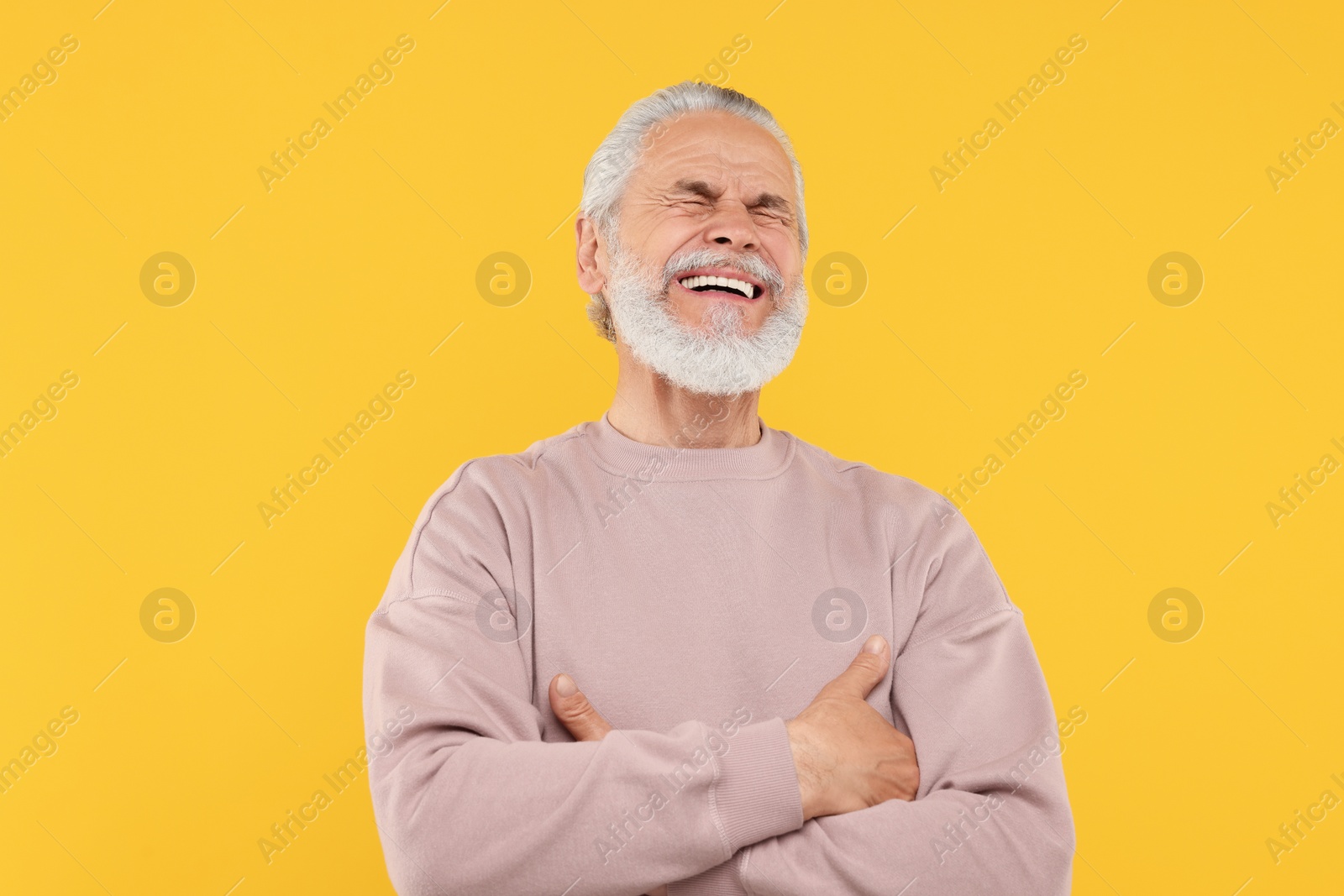 Photo of Portrait of emotional senior man on orange background