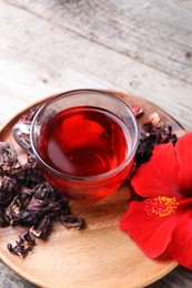 Photo of Delicious hibiscus tea and flowers on wooden table