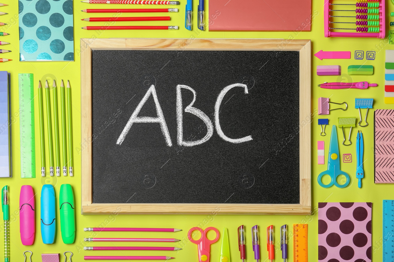 Photo of Flat lay composition with different school stationery and small chalkboard on color background