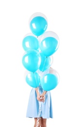 Young woman hiding behind air balloons on white background