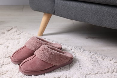 Photo of Pink soft slippers on carpet indoors, closeup