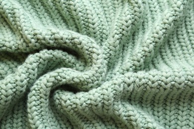 Photo of Beautiful pale green knitted fabric as background, top view