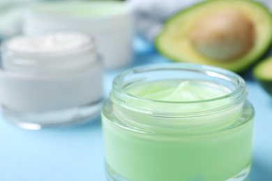 Photo of Open jar of cream on blue background, closeup