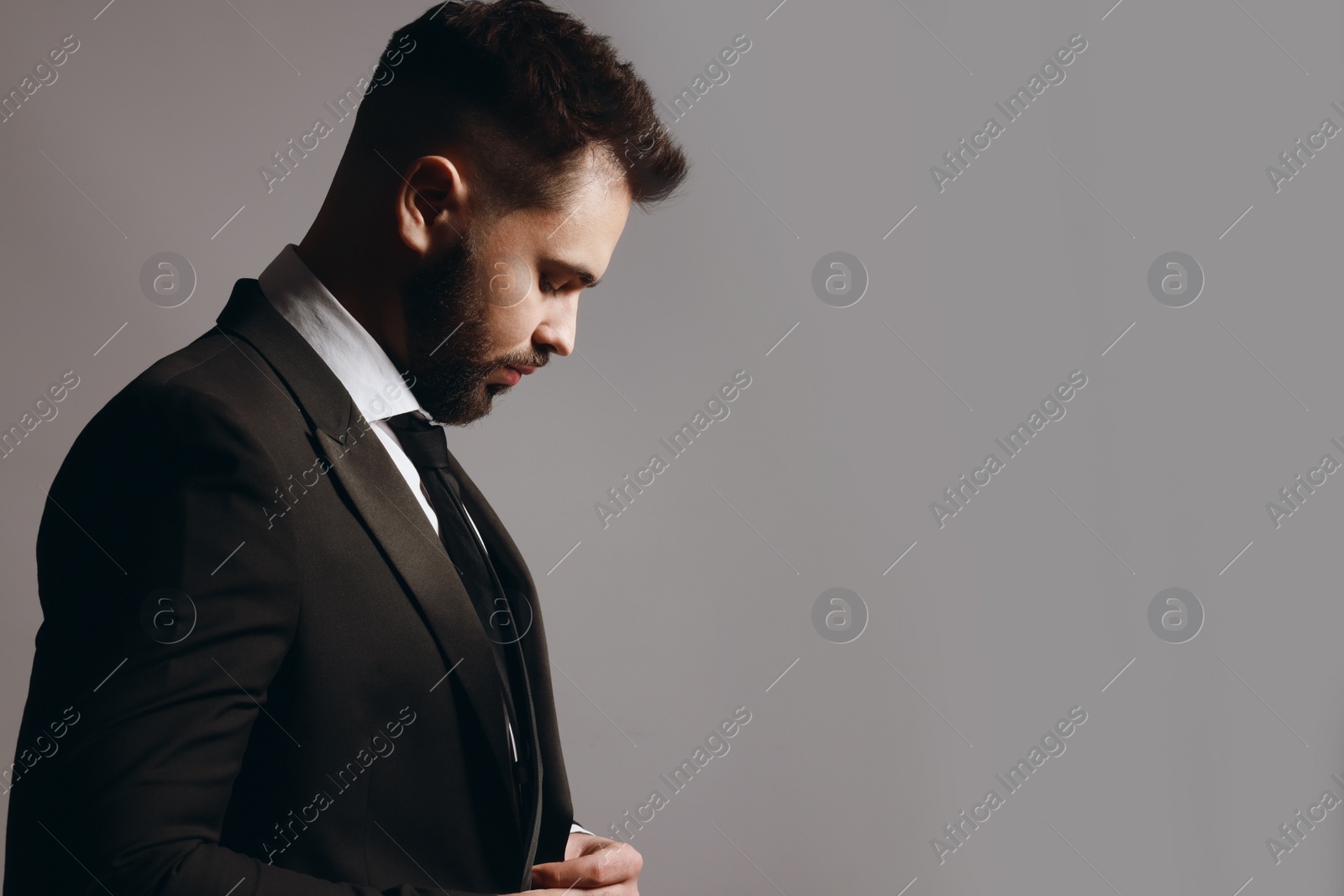 Photo of Handsome bearded man in stylish suit on grey background. Space for text