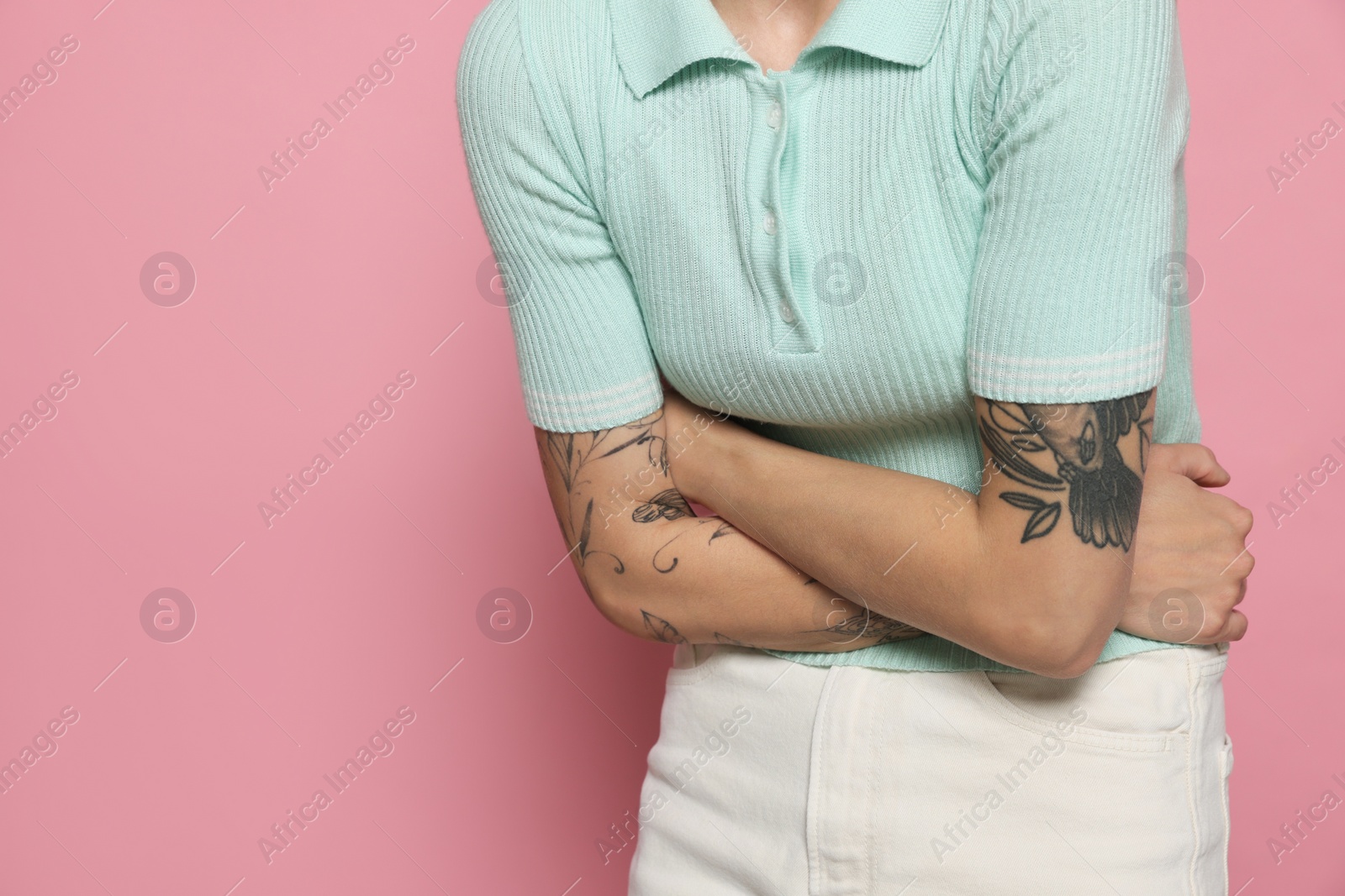 Photo of Young woman suffering from menstrual pain on pink background, closeup. Space for text