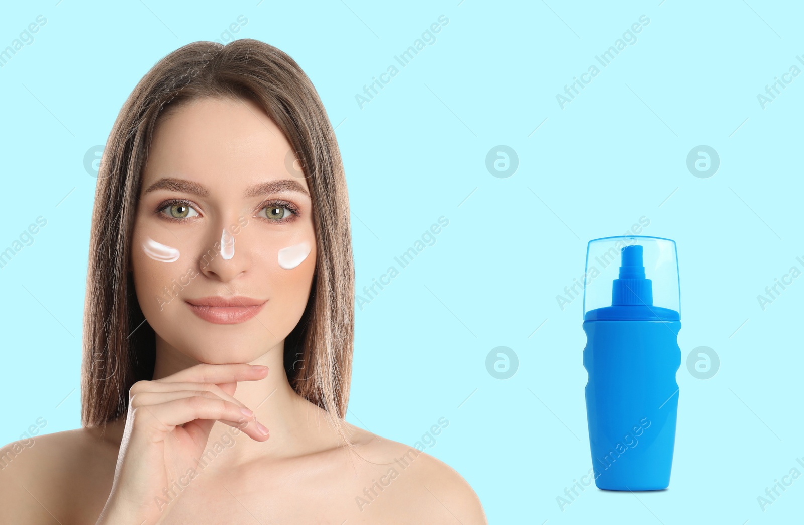 Image of Young woman and bottle of sun protection cream on light background