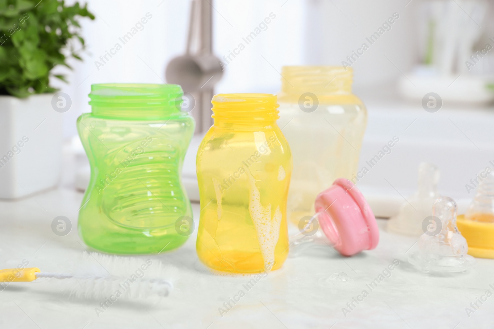 Photo of Baby bottles and nipples after washing on white countertop in kitchen