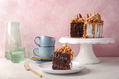 Piece of delicious homemade cake with caramel sauce and popcorn on table