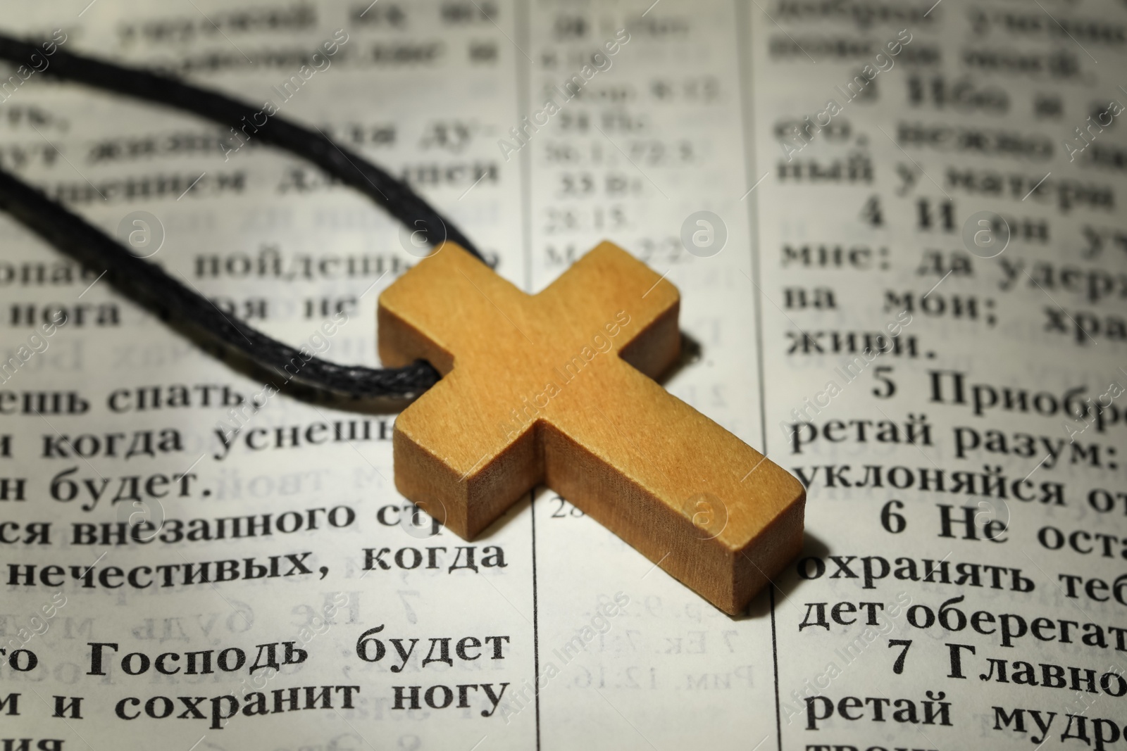 Photo of MYKOLAIV, UKRAINE - DECEMBER 21, 2021: Wooden cross on Bible, closeup. Text in russian