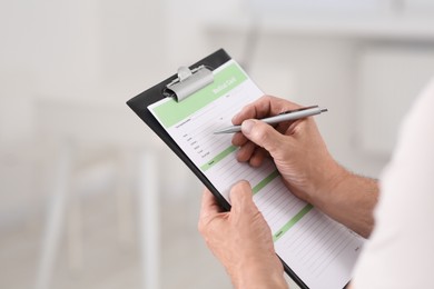 Photo of Patient filling his medical card in clinic, closeup. Space for text