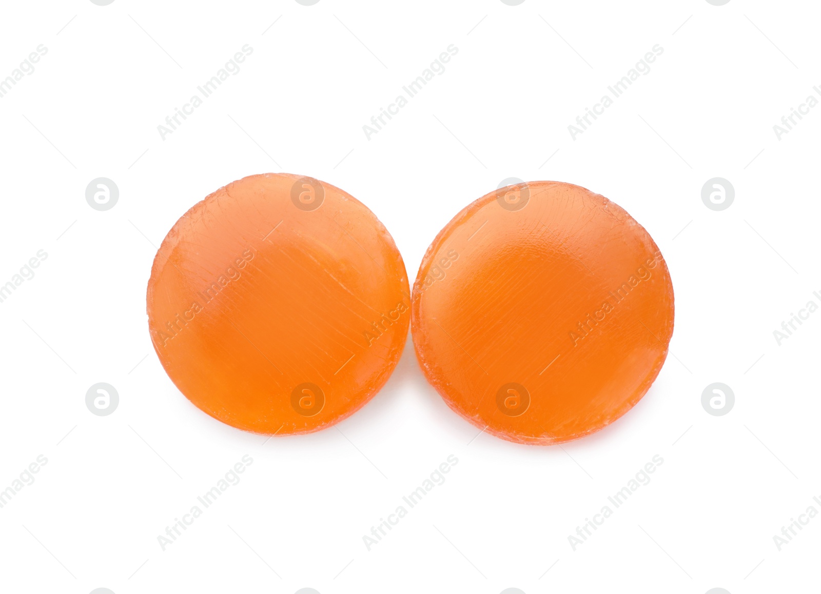 Photo of Two orange cough drops on white background, top view