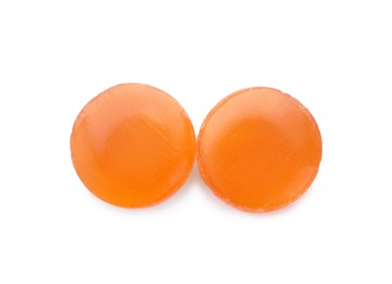 Photo of Two orange cough drops on white background, top view