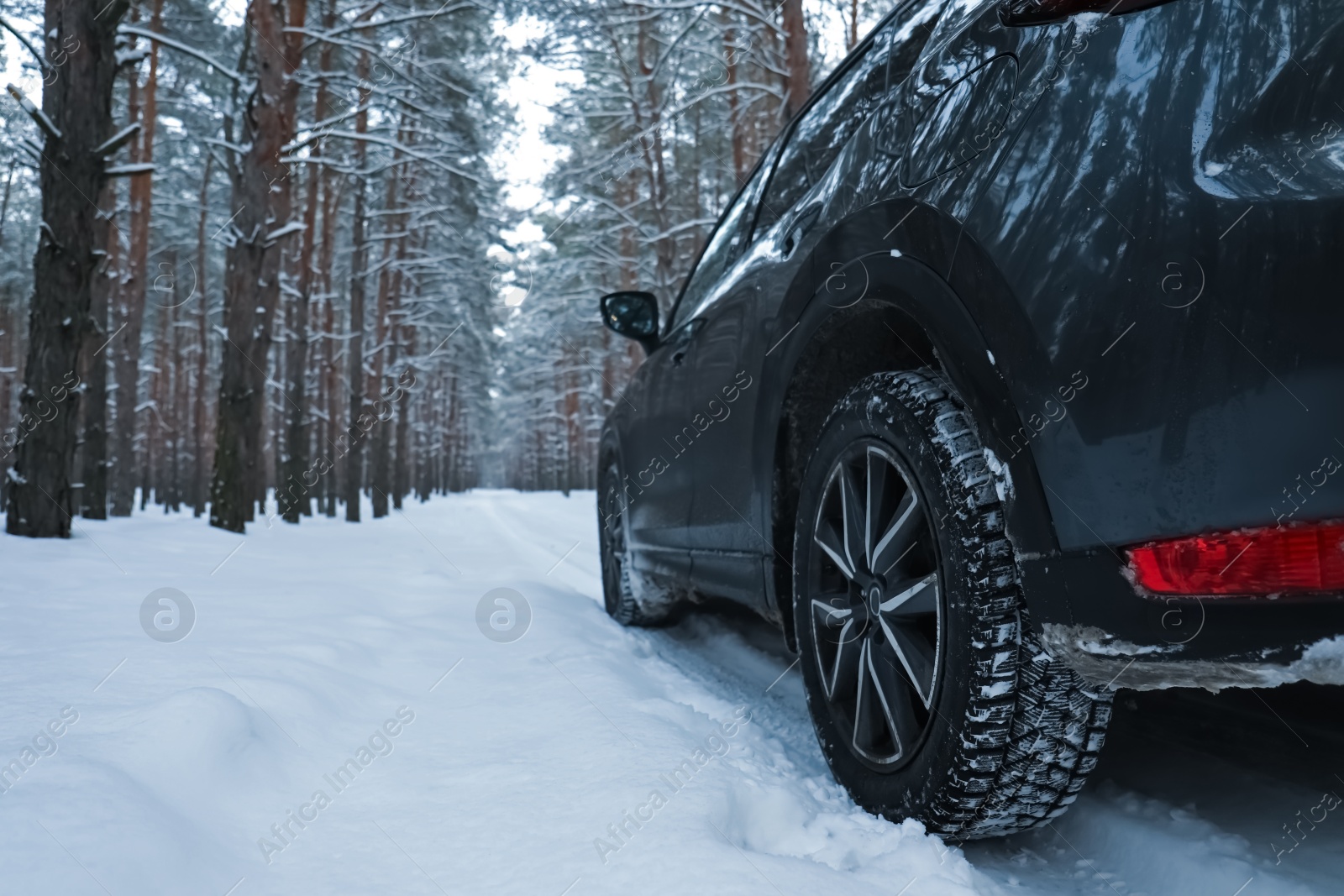 Photo of Snowy country road with car on winter day. Space for text