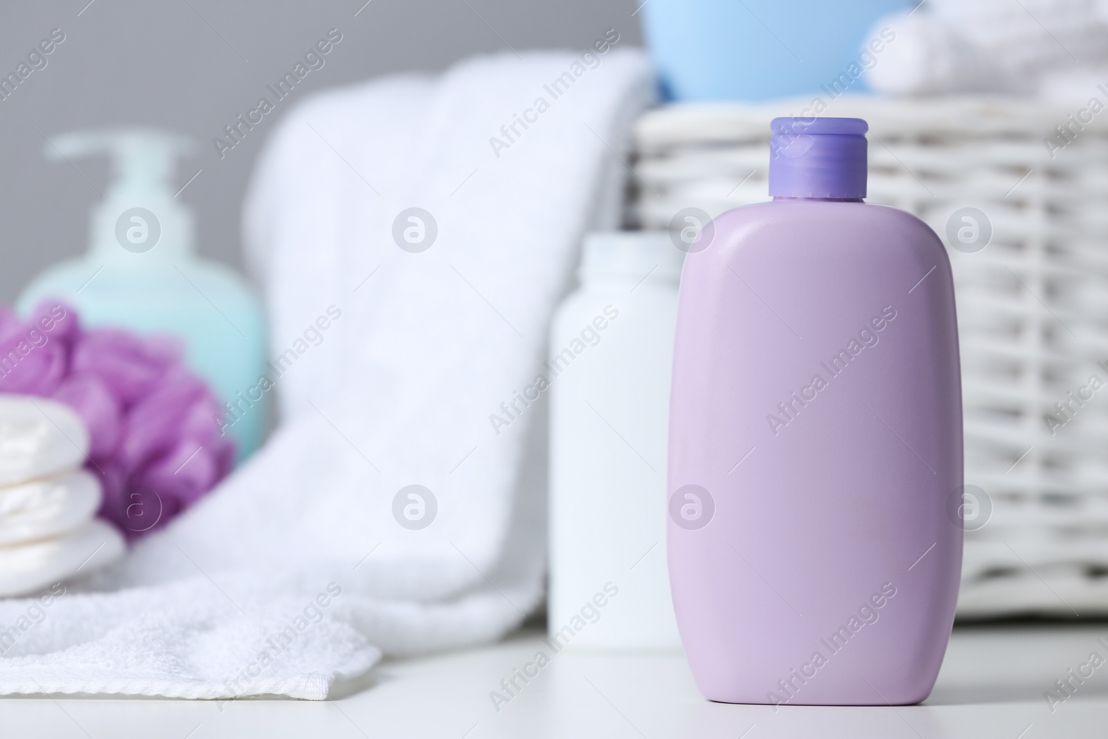 Photo of Bottle of baby cosmetic product on white table, space for text