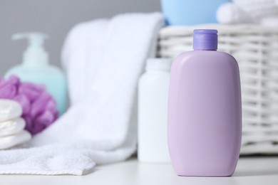 Bottle of baby cosmetic product on white table, space for text