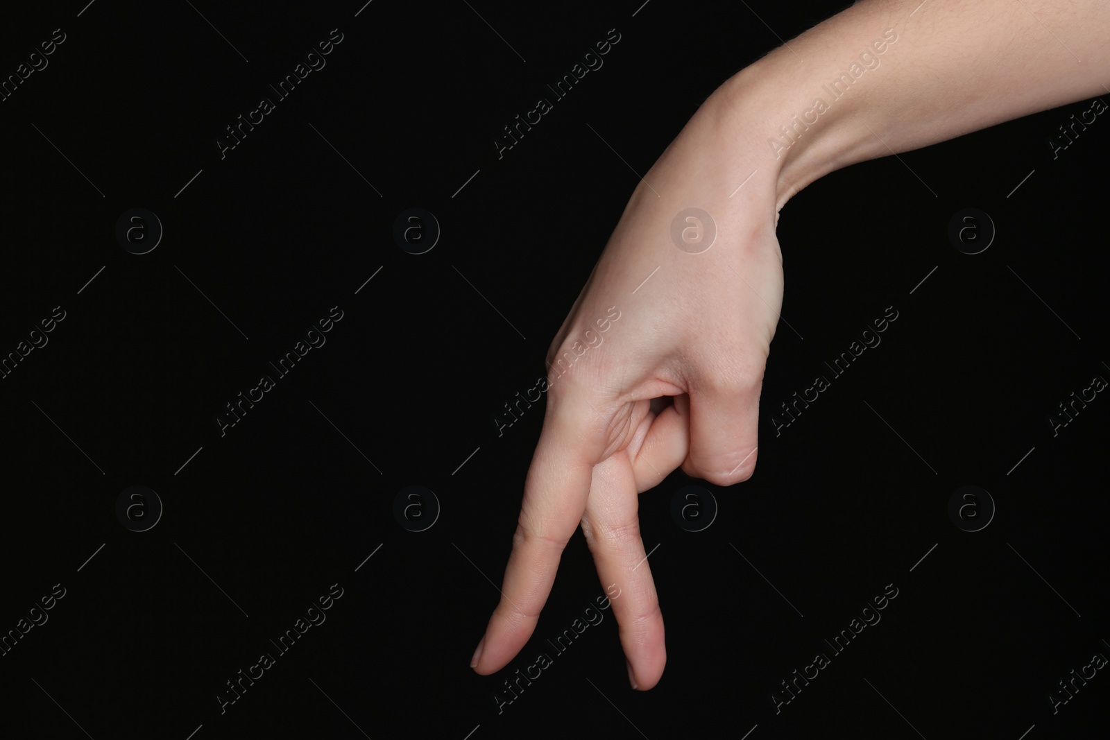 Photo of Woman imitating walk with hand on black background, closeup. Finger gesture