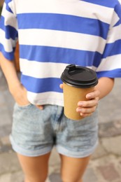 Coffee to go. Woman with paper cup of drink outdoors, selective focus