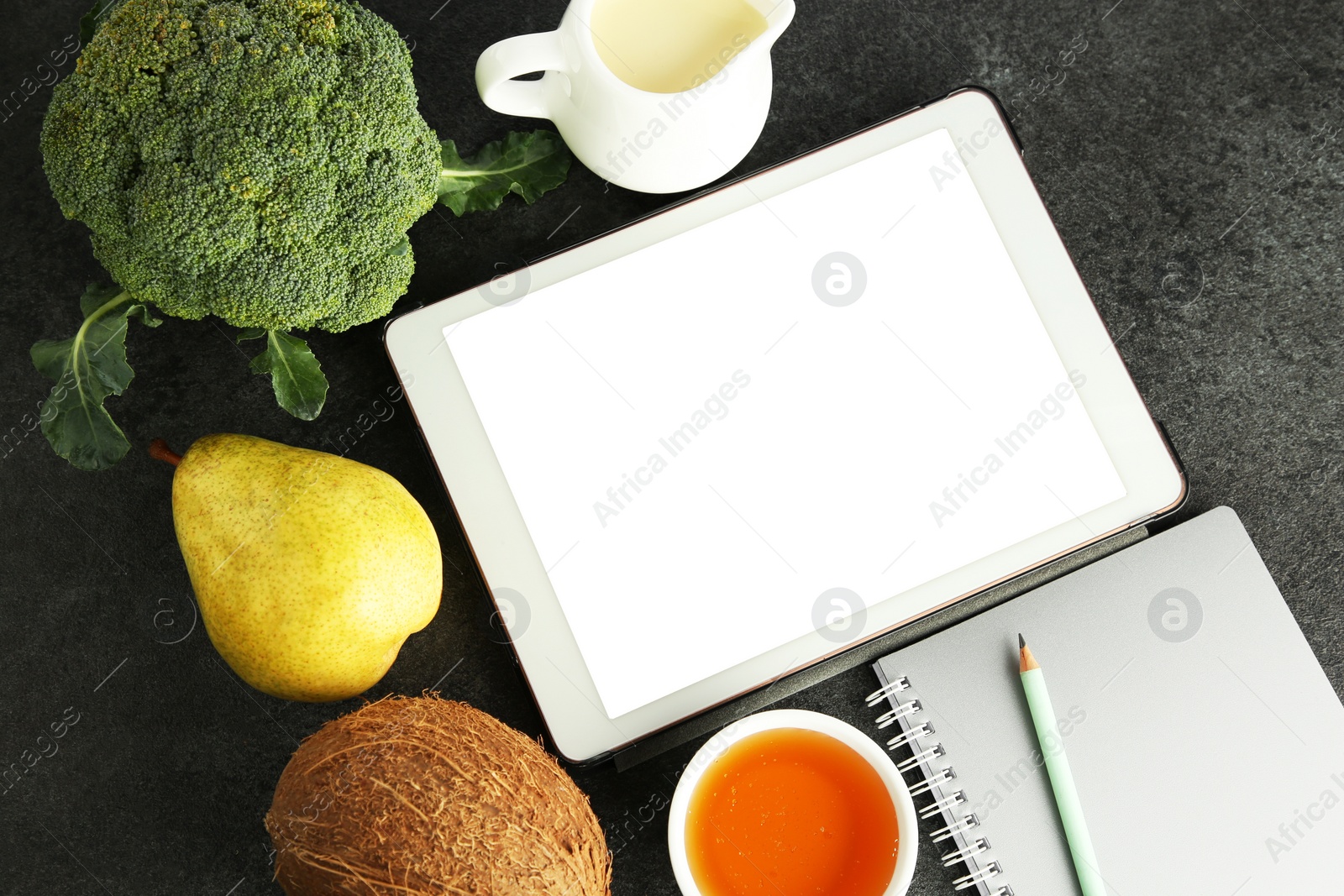 Photo of Glycemic index. Tablet with blank screen, different products and notebook on grey table, flat lay