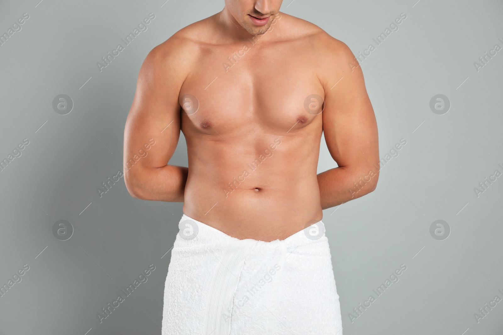 Photo of Young man with slim body on grey background, closeup view