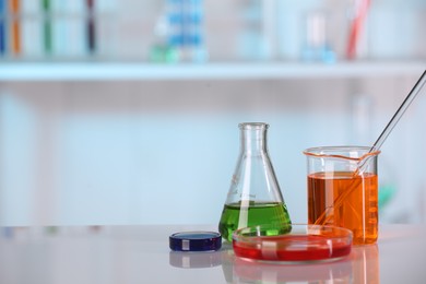 Laboratory analysis. Different glassware with liquids on white table indoors. Space for text