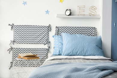 Photo of Comfortable bed with soft pillows in modern child room