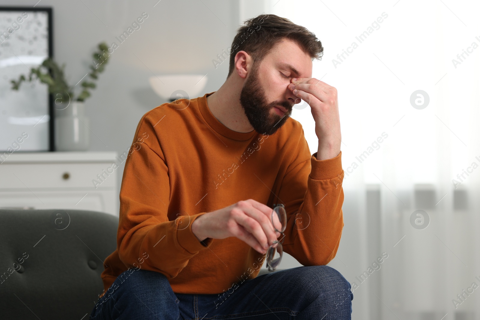 Photo of Overwhelmed man with glasses suffering at home