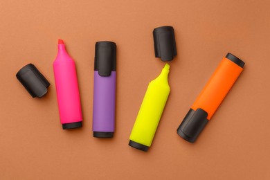 Photo of Bright color markers on pale orange background, flat lay