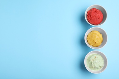 Different delicious ice creams on light blue background, flat lay. Space for text