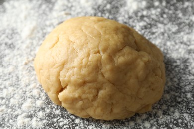 Making shortcrust pastry. Raw dough and flour on table, closeup