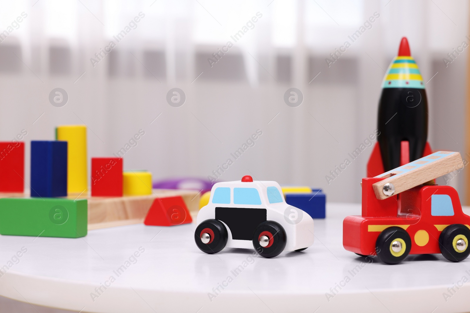 Photo of Different toys on white table in kindergarten, closeup