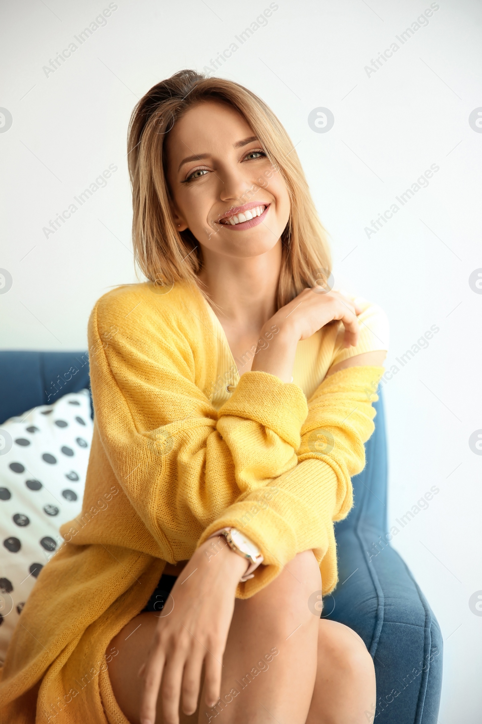Photo of Young beautiful woman with sexy legs in armchair indoors
