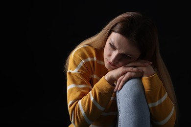 Photo of Portrait of sad woman on black background, space for text