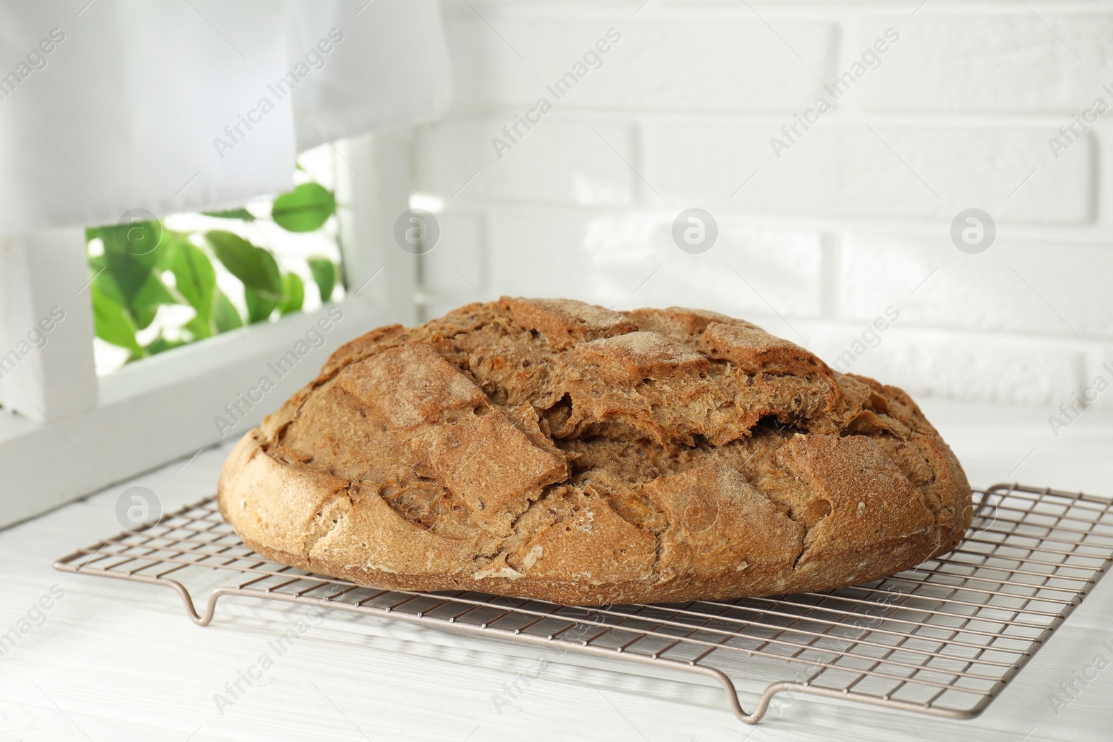 Photo of Freshly baked sourdough bread on white wooden table indoors