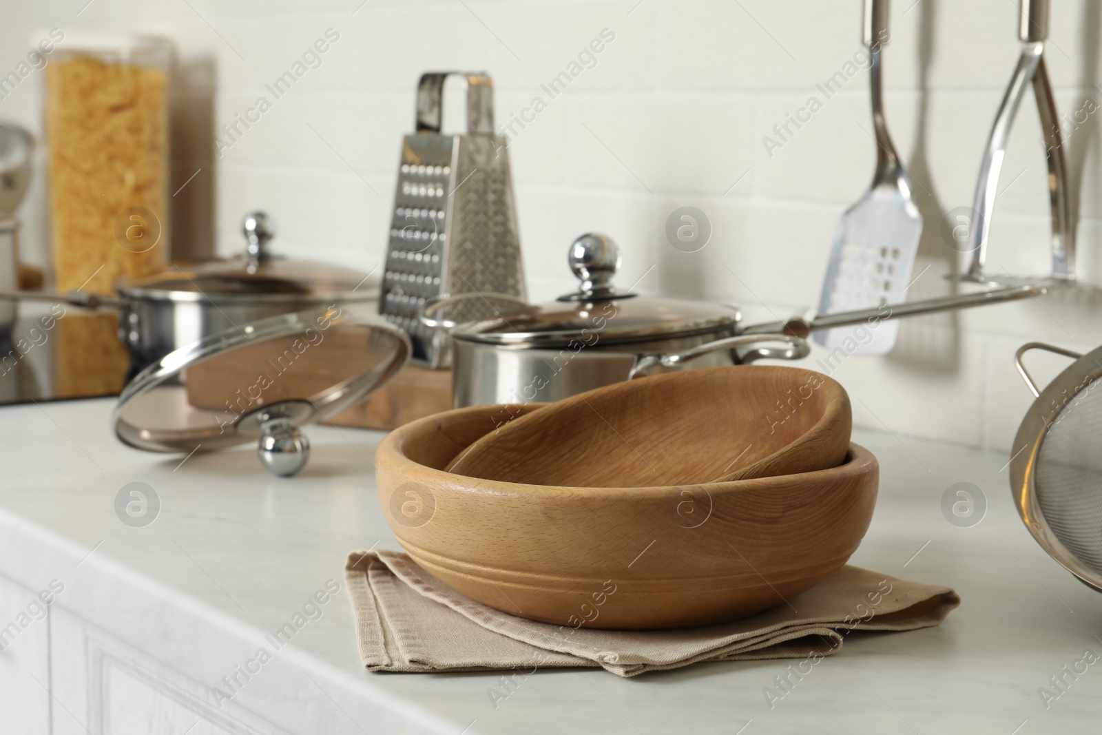 Photo of Wooden bowls and different cooking utensils on kitchen counter