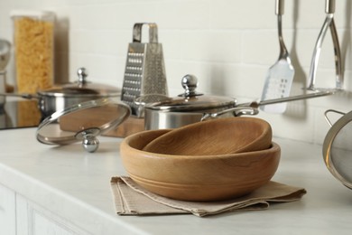 Photo of Wooden bowls and different cooking utensils on kitchen counter