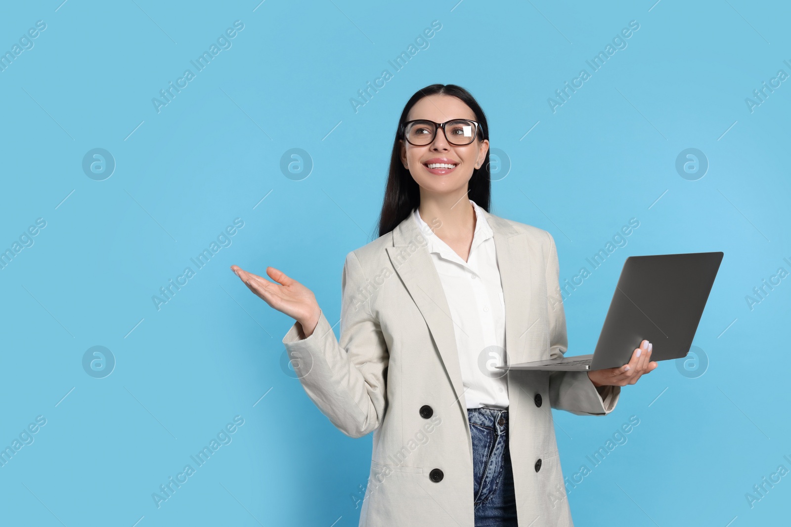 Photo of Happy woman with laptop on light blue background