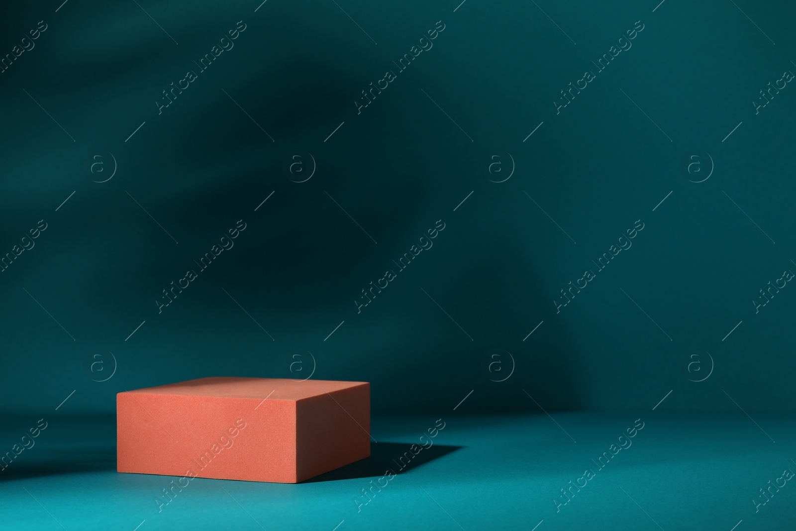 Photo of Orange stand on teal background, space for text. Stylish presentation for product