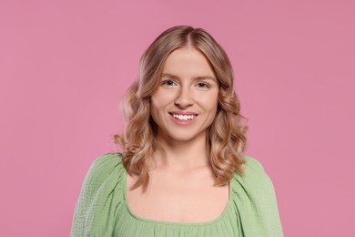 Photo of Portrait of beautiful woman with blonde hair on pink background