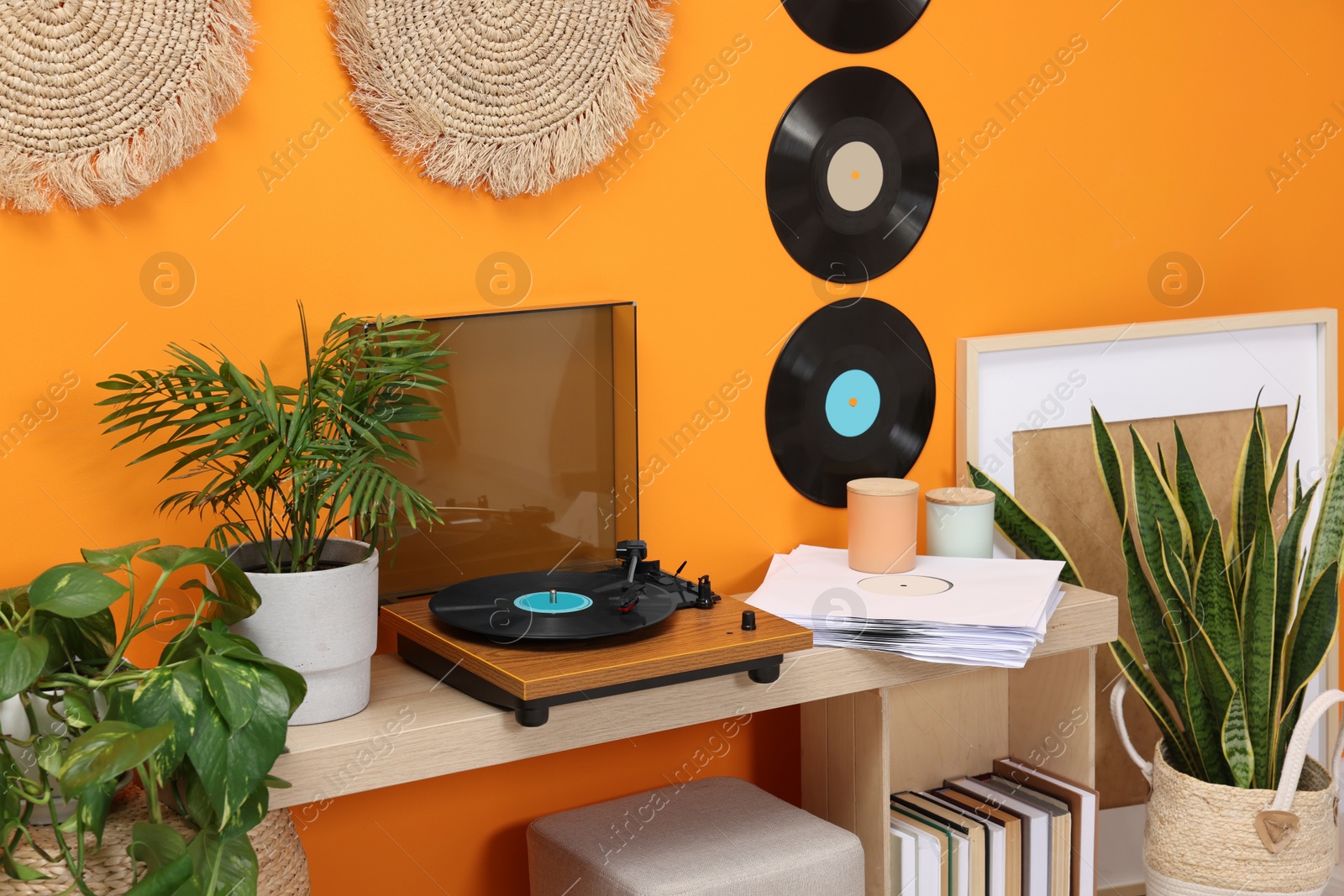 Photo of Stylish turntable with vinyl record on console table in cozy room