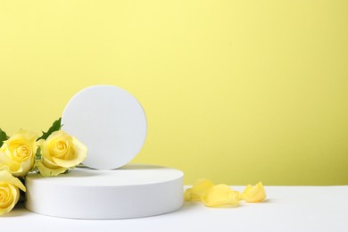 Beautiful presentation for product. Geometric figures and roses on white table against yellow background, space for text