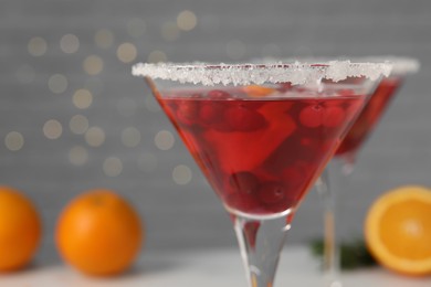Photo of Tasty cranberry cocktail in glass on light background, closeup