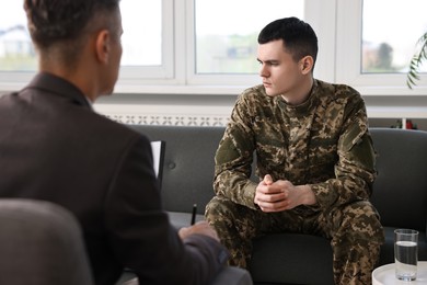 Professional psychotherapist working with military man in office