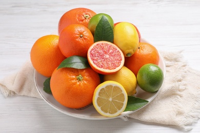 Photo of Different citrus fruits on white wooden table