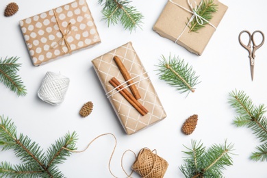 Composition with Christmas tree branches and gift boxes on white background